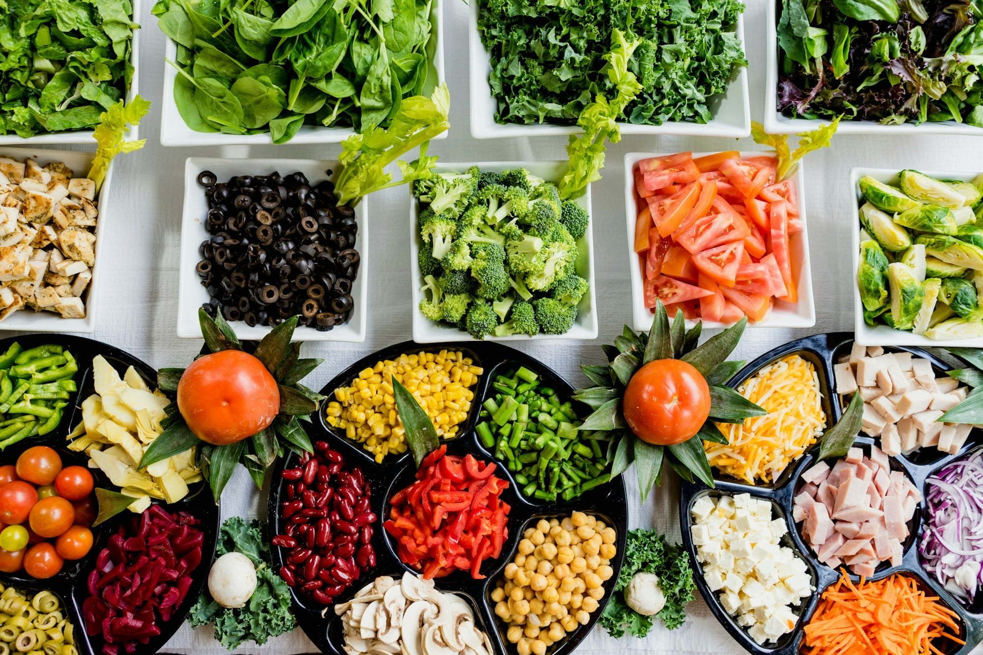 Raw vegetables, meats, cheeses and mushrooms in trays and dishes that show a healthier way to eat.